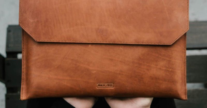 person holding veg tanned leather laptop case for 13 inch laptops - ethically made by MADE FREE artisans