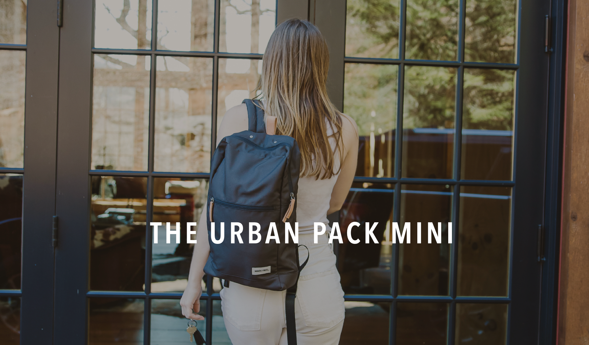 Woman carrying MADE FREE mini backpack in black, ethically made from recycled polyester