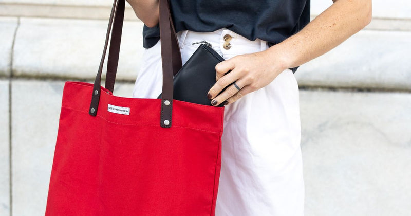 woman carrying organic cotton red tote bag, ethically made by global artisans