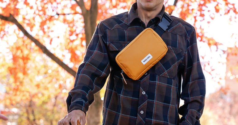 young man wearing mustard crossbody hip pack ethically made from recycled materials