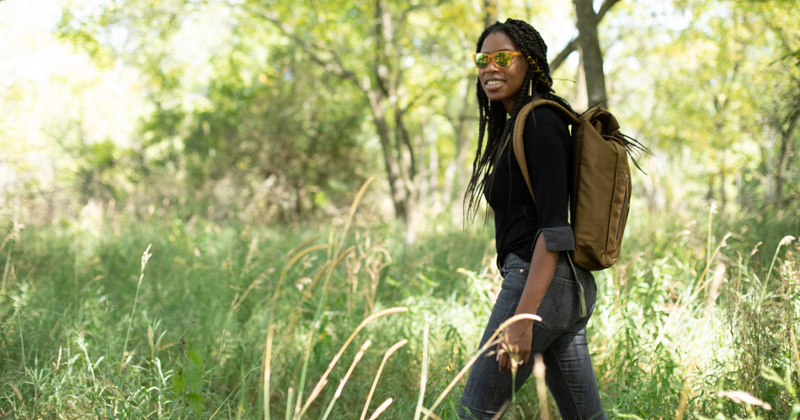 Woman hiking outdoors with roll top backpack