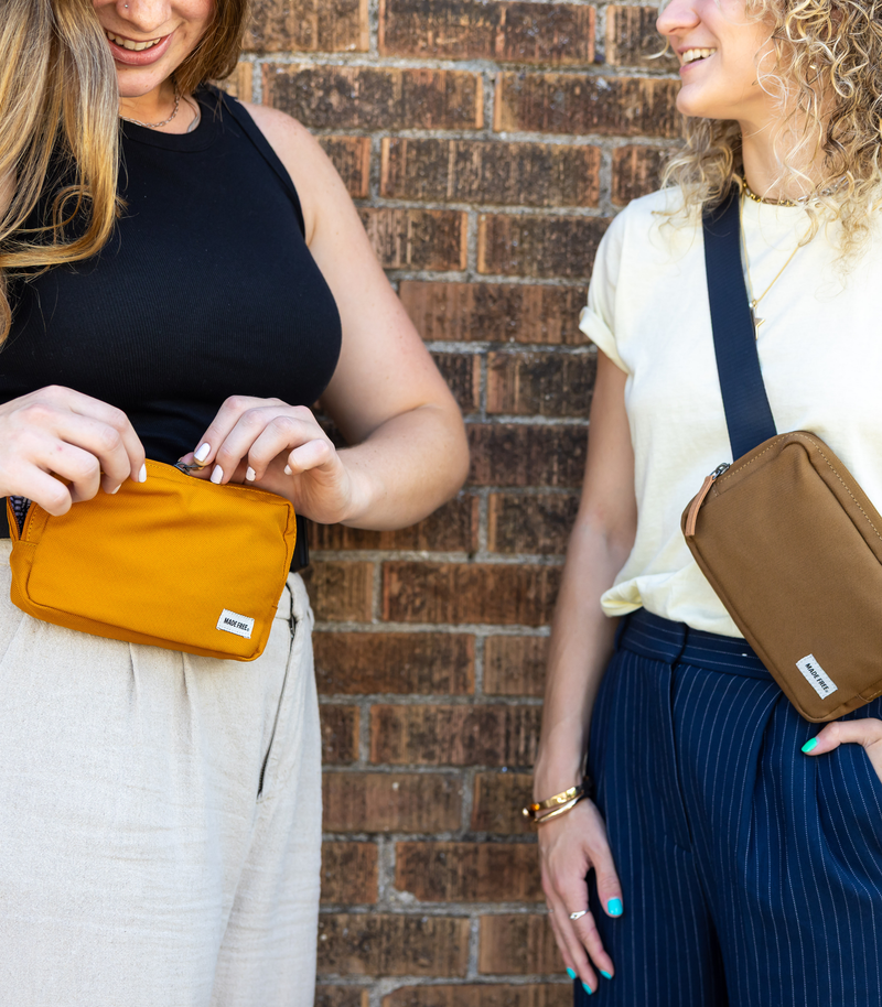 Two women wearing MADE FREE sustainable hip packs in mustard and brown