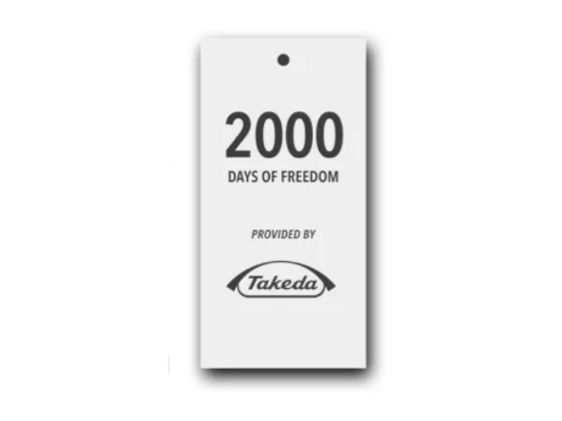 A white tag with black text that reads "2000 Days of Freedom provided by Takeda," with the Takeda logo at the bottom.