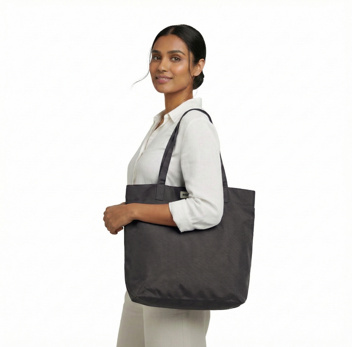 MADE FREE Day Tote AW in charcoal worn by model in studio setting