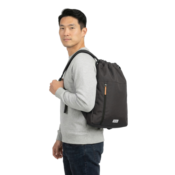 MADE FREE Sport Bag AW in charcoal worn by model facing left in studio setting